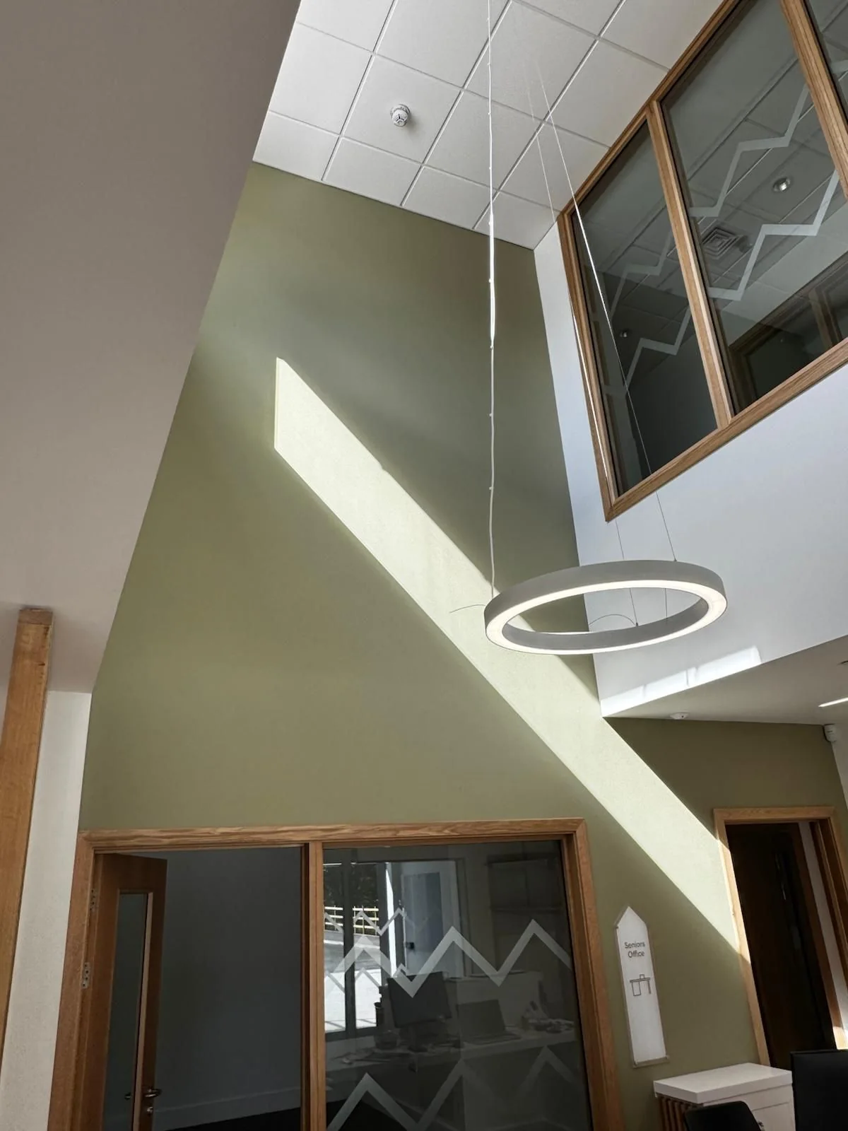 Double-height green feature wall inside the Greenock community hub