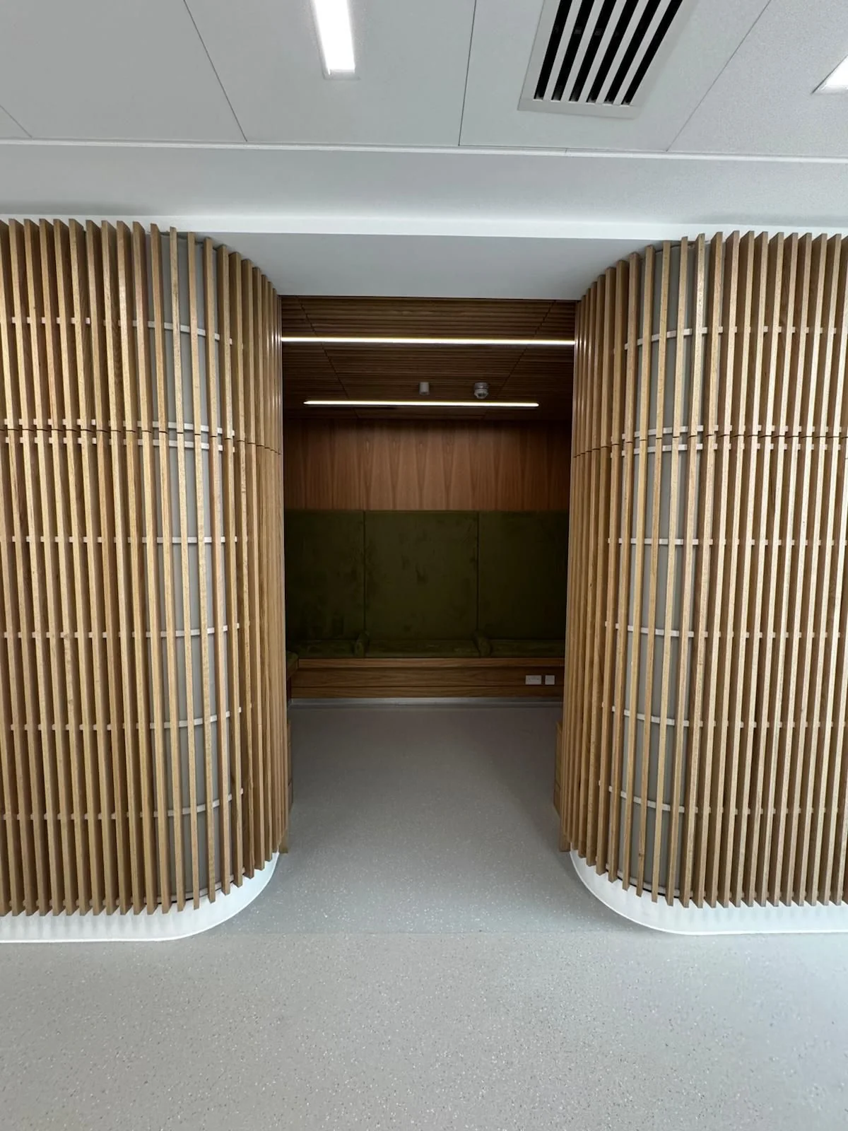 Quiet seating area enclosed by curved timber screens